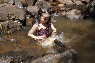 Little girl playing at the waterfall in Brotas, rural area of ​​São Paulo Brazil.