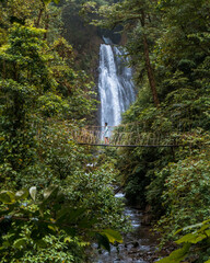 Waterfall and suspension bridge in the middle of the mountains 