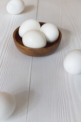 White eggs in a bowl on a wooden table - 426193302