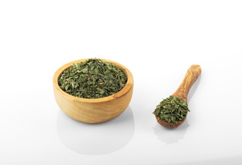 Fototapeta na wymiar Dried parsley. Dried parsley in wooden bowl, on white background. Parsley.