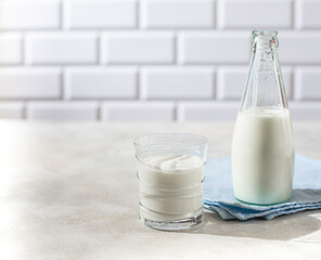 Fermented drink kefir, yogurt in a glass jar on a light background. Probiotic cold fermented dairy drink. Healthy gut flora concept.