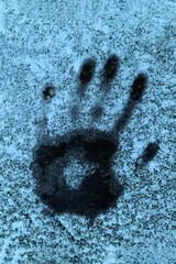 Handprint on the snowy ice. Blue abstraction background with palm footprint