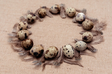 Quail eggs wreath with feathers on bagging fabric