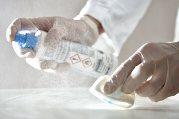 Laboratory agent nurse doctor cleaning desinfecting surface with desinfection reagent spray