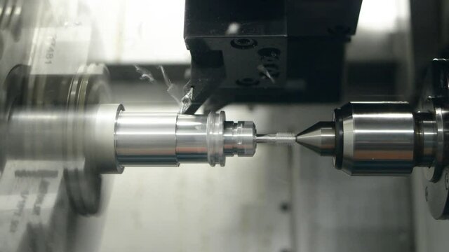 cnc machine at work. cutting tool processing steel metal detail on turning cnc lathe machine in workshop