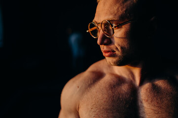 Muscular fitness shirtless man in glasses.