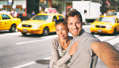 New York travel selfie tourists couple taking photo on NYC city street summer holiday vacation with...