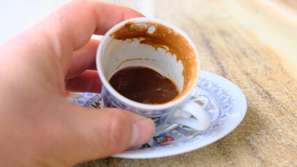 Traditional turkish coffee pot with iznik tile shape around it. Finished coffee and coffee grounds looking to fortune teller