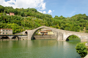 Fototapeta na wymiar Historic Bridge in Italy - Ponte Della Maddalena over river Serchio. Lucca, Italy