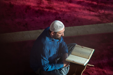 muslim man praying Allah alone inside the mosque and reading islamic holly book
