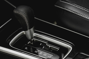 Close up of the automatic gearbox lever. Gear shift handle in a modern car. Modern car interior detail.