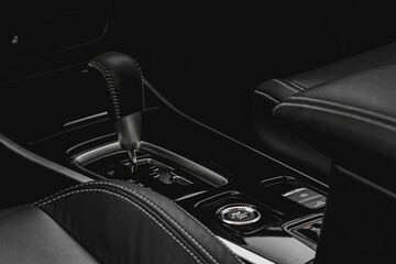 Close up of the automatic gearbox lever. Gear shift handle in a modern car. Modern car interior detail.