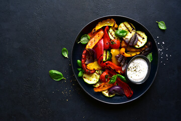Grilled vegetables with yogurt sauce. Top view with copy space.