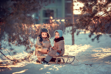 Cute little boy in earflaps hat and his baby sister in blue bonnet and retro coat are sitting on...