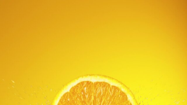 Super slow motion of orange slice falling into juice. Filmed on high speed cinema camera, 1000 fps.