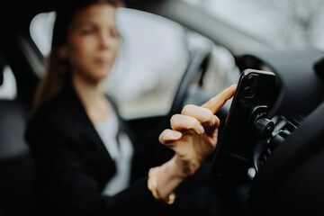 Female driver using smart phone as a navigation device in the car.