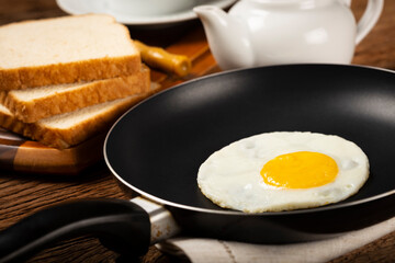 Breakfast with fried egg in the frying pan.