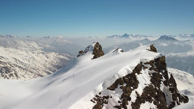 Sorvolo cresta innevata e apertura su valle d'Aosta