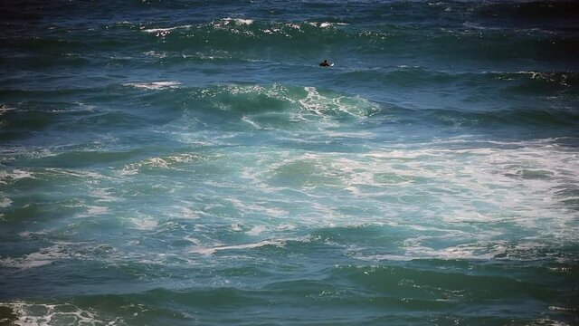 Up and Down- a lone surfer shows determination in disorganized California waves.