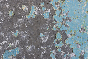 Peeling paint on the wall. Old concrete wall with cracked flaking paint. Weathered rough painted surface with patterns of cracks and peeling. High resolution texture for background and design. Closeup