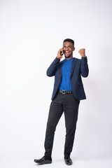 young black businessman feeling excited while making a phone call and rejoices