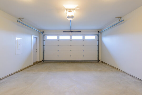 An empty garage with door and windows.