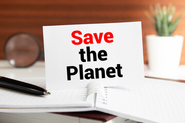 closeup of a label-shaped chalkboard with the text save the planet in the trunk of a tree