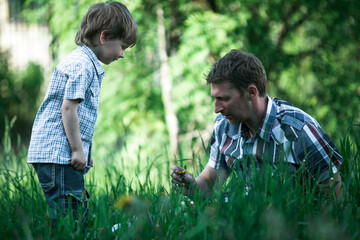 Fototapeta premium Daddy and his little son playing in the green Park.
