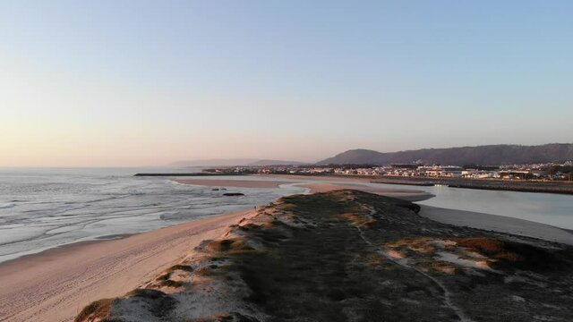 DRONE AERIAL FOOTAGE: Northern Litoral Natural Park in Ofir, Fao, Esposende, Portugal at sunset. The two sides of Restinga de Ofir. One facing the ocean, the other the estuary of C&aacute;vado River.