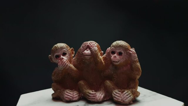 The statuette of three wise monkeys rotates