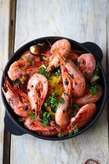 Shrimp in shells in a frying pan. Delicious fried prawns with spices.