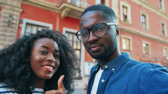 Close up of young cheerful african american couple having fun standing on outside posing and grimacing at camera.