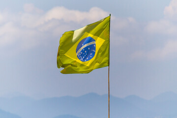 faded brazil flag outdoors on a rio de janeiro beach.
