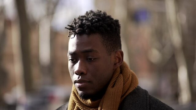 Pensive Young black African man walking outside in city