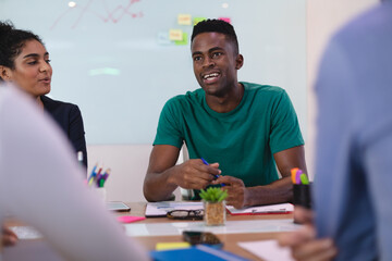 African american man speaking to diverse group of people in meeting room