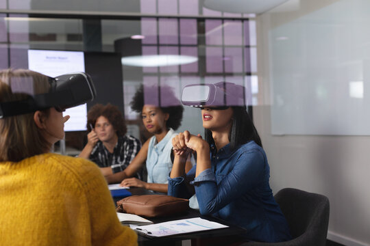 Diverse group of creative colleagues wearing vr headset in meeting room