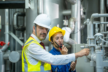 Electrical engineer working in control room of a modern thermal power plant at large industry...