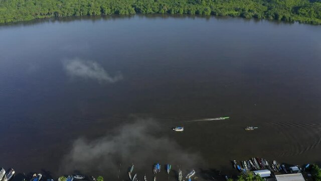 BINACIONAL DRONE AMAPA AMAZONIA DAWN WITH MIST BOAT ON THE OIAPOQUE RIVER DIVISES WITH FRENCH GUIANA