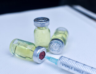 Vial of drugs injection or vaccine with syringe needle on a white background for cure and prevention of sickness 