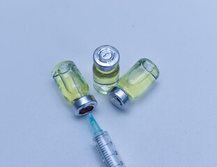 Vial of drugs injection or vaccine with syringe needle on a white background for cure and prevention of sickness 