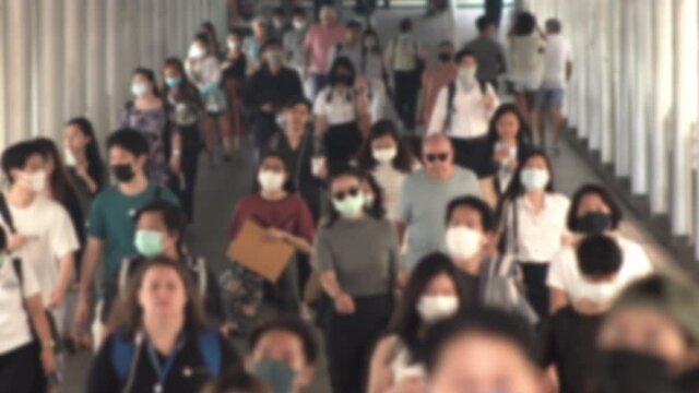 4K, Blurred defocused view of Concept of coronavirus quarantine, MERS-Cov. Large crowd of business people with medical face mask. Air pollution.