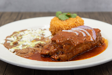 Large slap of Chile Colorado entree meat, refried beans, and rice drenched in the red sauce.
