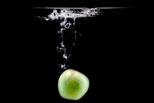 one ripe green apple fell into the water