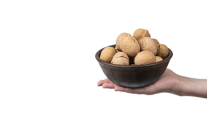 A woman's hand with a large bowl filled with walnuts isolated on a white background.