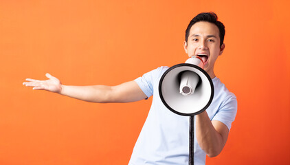 Asian man holding megaphone and shouting