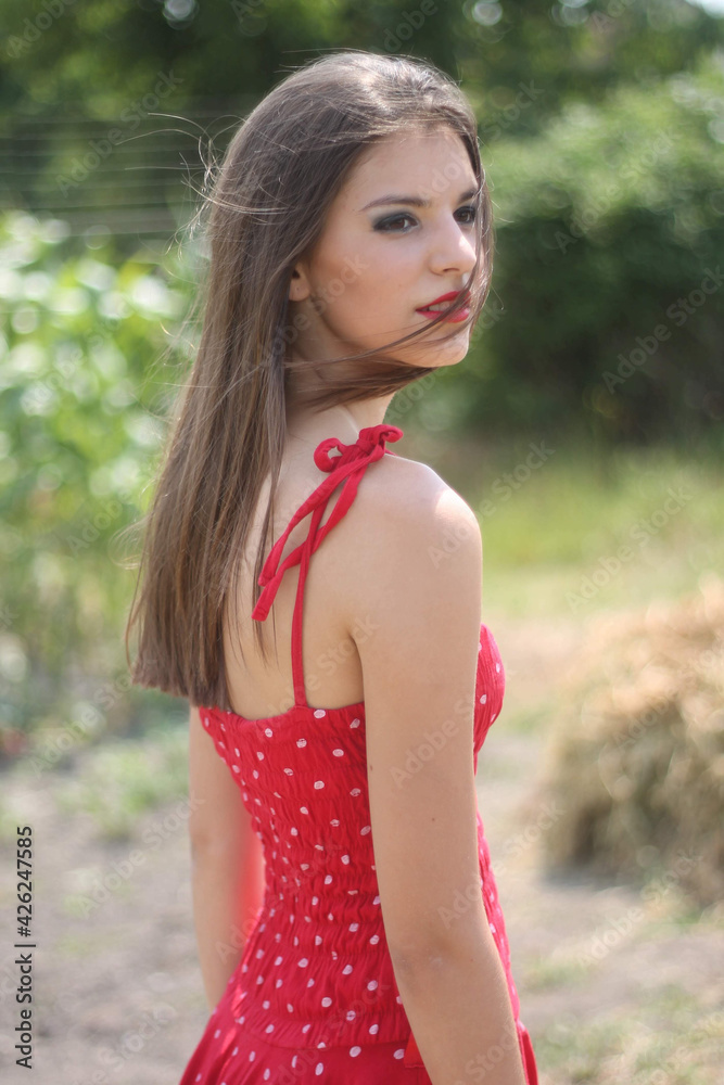 Sticker vertical shot of a beautiful young caucasian lady wearing a red polka-dot dress