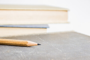 Obraz premium Wooden pencil with books on a table