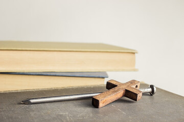 Holy Bible with nail and wooden cross on a table