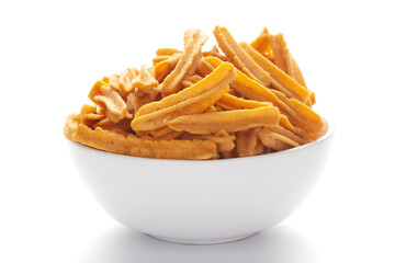 Close up of salted Soya Sticks Indian namkeen (snacks) on a ceramic white bowl.