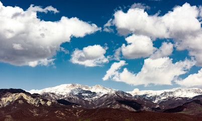 Cloud over snow capped mountain peaks